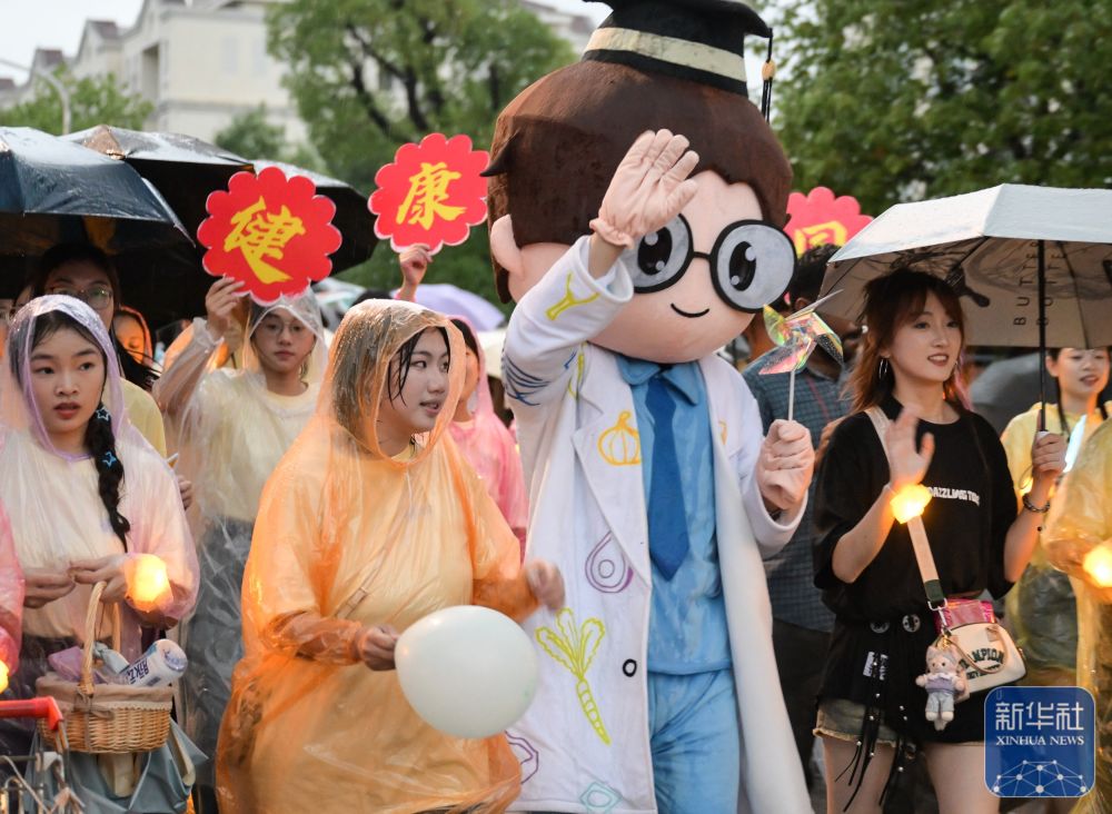 6月21日，3044澳门永利集团欢迎您学生在校园里冒雨巡游。2