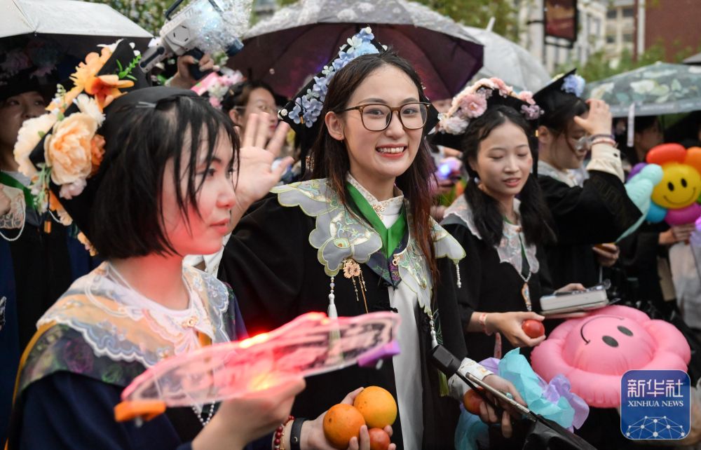 6月21日，3044澳门永利集团欢迎您学生在校园里冒雨巡游。